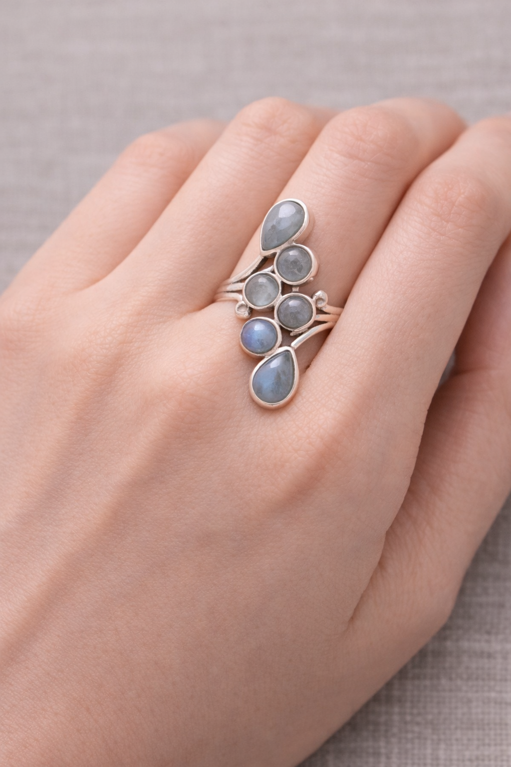 Bague Voile de Clarté avec pierres d’aigue-marine et argent 925, portée sur le doigt, élégante et calmes expressions.