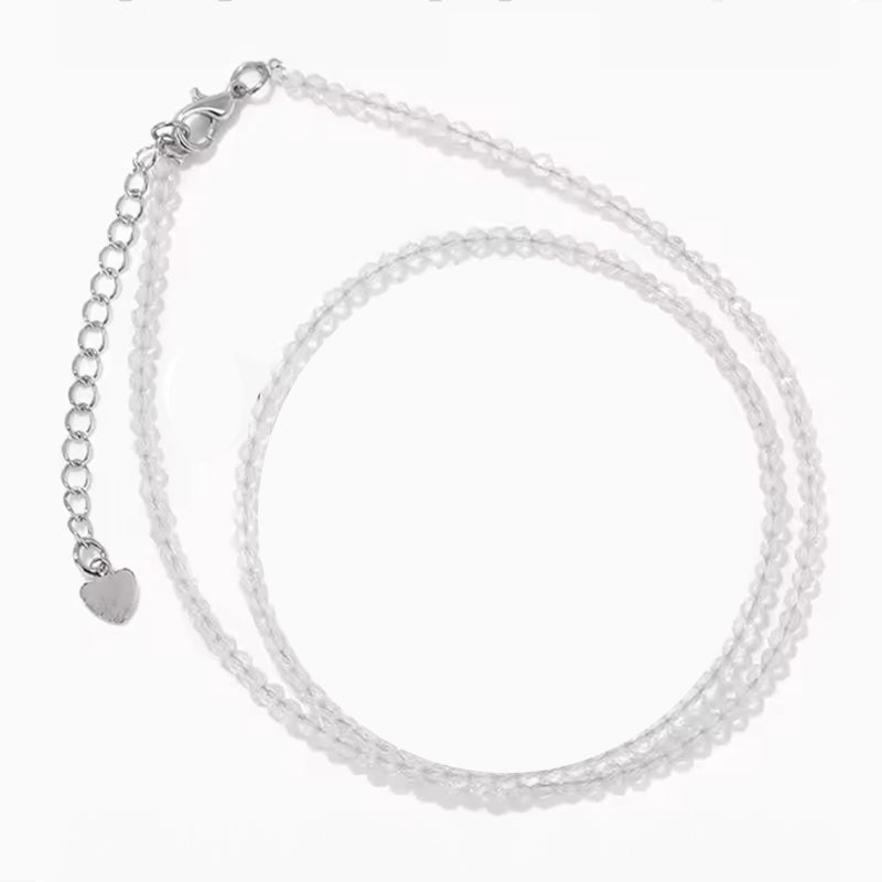 Collier Clarté d’Âme en Cristal de Roche Facetté: double chaîne à facettes transparentes avec fermoir et petit pendentif cœur.