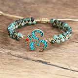 Bracelet en perles turquoise et pierre naturelle avec nœud azur et or, symbole om, fermoir ajustable sur corde, ambiance éthnique africaine.