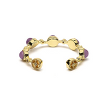 Bague ouverte en or avec améthystes violettes et détails rotatifs, design texturé évoquant sérénité et clarté intérieure.