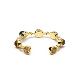 Bague ouverte dorée avec pierres œil de tigre, design segmenté et motifs gravés, évoquant protection et confiance.