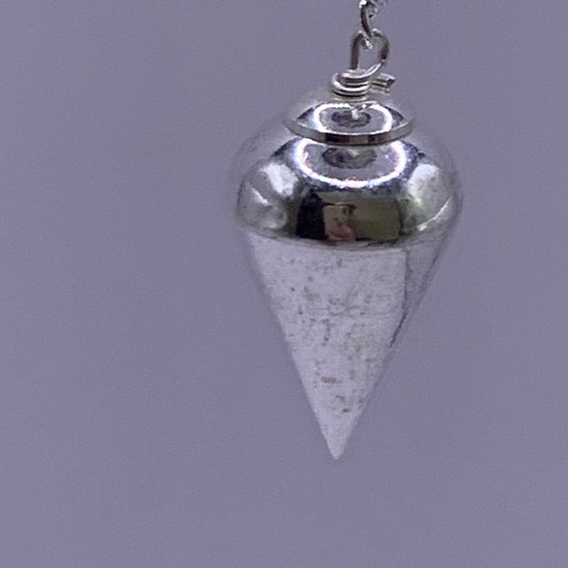 Pendule Divinatoire en Acier - forme conique: capuchon métallique et chaîne visibles avec une pointe conique argentée suspendue.